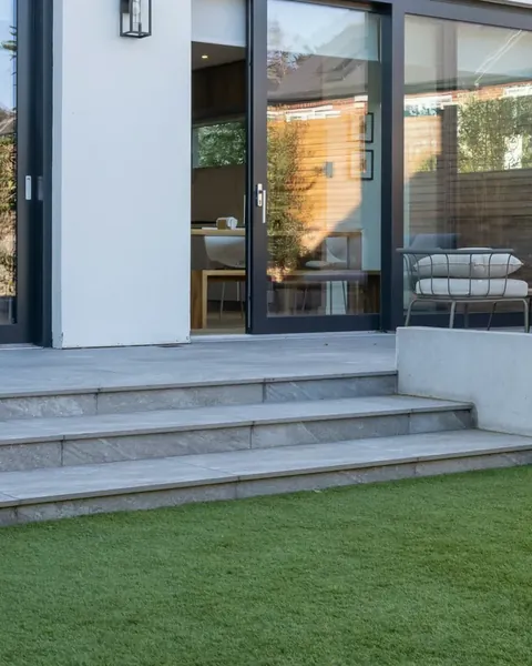 Casa moderna con prato sintetico verde e uniforme davanti alle vetrate